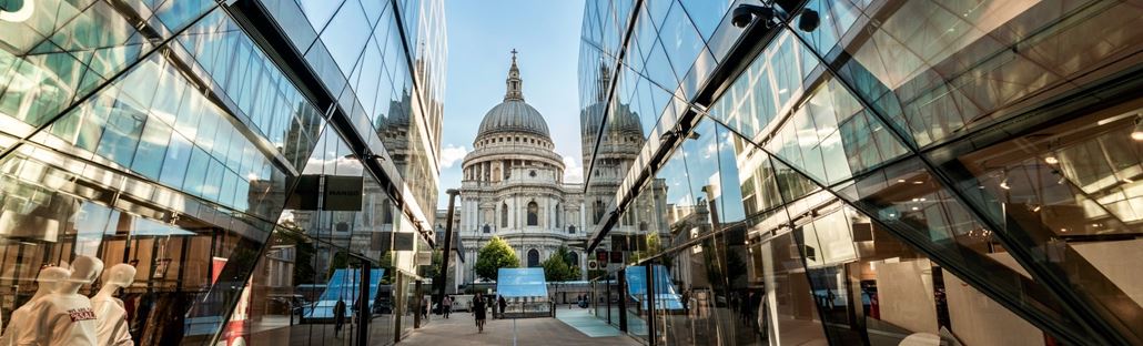 Glass windows of St Paul's One New Change shopping centre, with St Paul's Cathedral in the background.