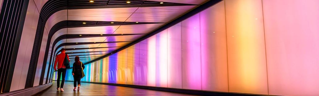 Two people walking through King's Cross tunnel.