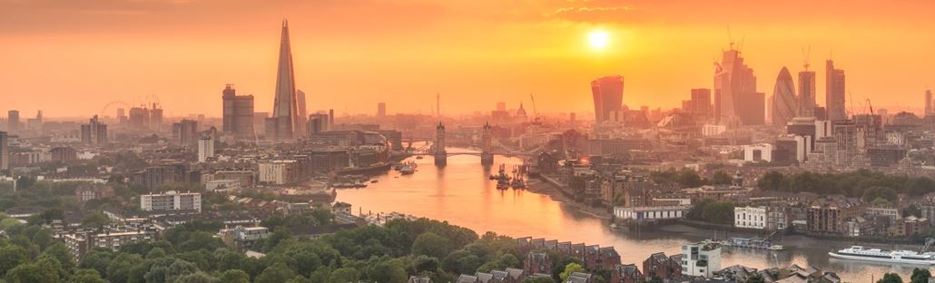 London skyline at dusk with sky illuminated orange.