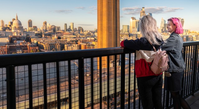 Two people standing looking at the view from Tate Modern.