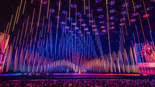 London offers a thrilling mix of immersive experiences, from groundbreaking shows to dining experiences and outdoor adventures. Credit: Johan Persson. Image courtesy of ABBA Voyage. ABBA Arena stage lit up in pink, orange and purple lights during a live performance of ABBA Voyage in London.
