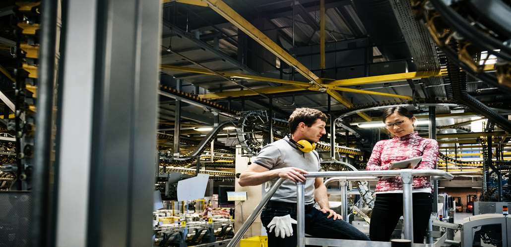 Two people inside a manufacturing factory