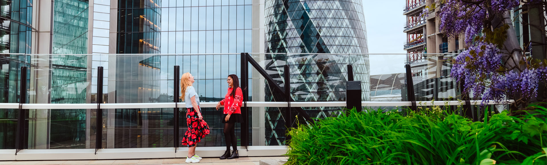 Two people laughing together at a rooftop garden in the City of London