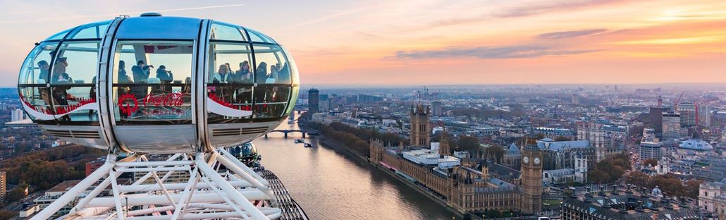 View over the Houses of Parliament, Westminster and beyond from a London Eye pod filled with visitors.