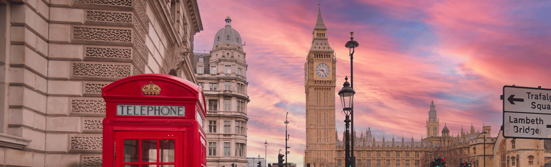 Pink sunset behind Big Ben with red telephone box in the foreground